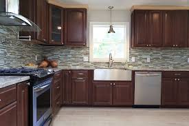 Cherry Cabinets With Mosaic Glass And Stone Backsplash With Stainless Steel Farm Sink And Accent Pe Wood Kitchen Backsplash Backsplash Cherry Cabinets Kitchen