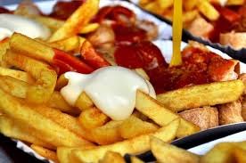 Kızarmış domuz sosisinin üzerine ketçap (veya domates salçası) ve toz halinde köri serpilerek servis. Currywurst What It Is Why I Love It