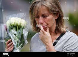 A woman lays flowers with tributes in Plymouth, Devon, where five people  were killed by gunman Jake Davison in a firearms incident