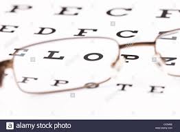 a pair of reading glasses sitting on a eye test chart with