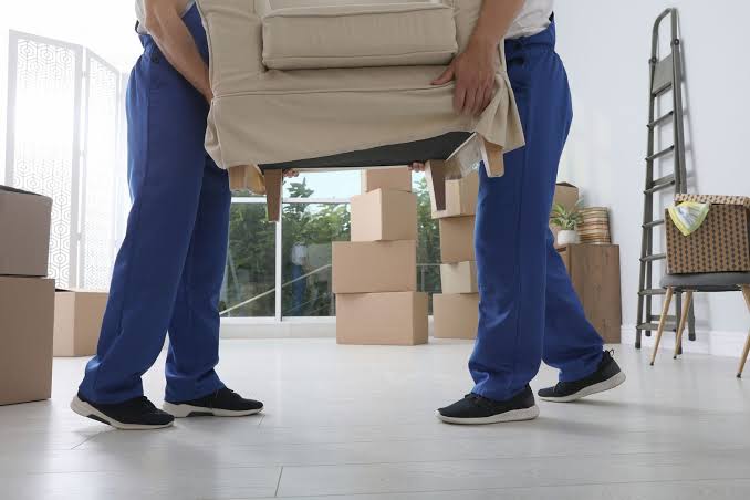 Professional movers placing protected furniture inside a new Mauritian home