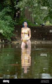 Eine blaue behaarte Frau im Bikini Badeanzug steht in einem Fluss in die  Kamera schaut Stockfotografie - Alamy