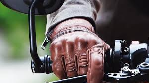 Motorista con guantes homologados circulando por carretera