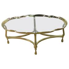 Race track oval glass, with ogee edge, on a brass base with four half oval stretchers creating a diamond pattern in the centre. Oval Hollywood Regency Brass And Glass Top Coffee Table Attributed To Labarge At 1stdibs