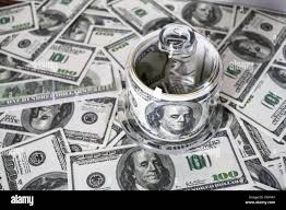 Money In A Glass Container On The Background Of One Hundred Dollar Bills Counterfeit Money Stock Photo Alamy