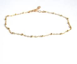 Gold ankle bracelets are often adorned with gemstones and pair beautifully with elegant heels and matching gold accessories. Delicate Gold Anklet Bracelet Gold Beaded Chain Gosia Meyer Jewelry