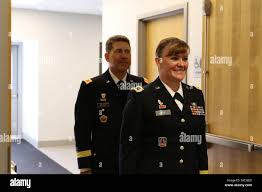 Army Reserve Brig. Gen. Nikki Griffin-Olive (left center), deputy commander  of sustainment, 335th Signal Command (Theater) unfurls the brigadier  general officer flag with her husband, Col. Jeffrey A. Olive (right),  commander of