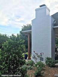 This is a beautiful yellow home in the country with a gabled roof topped with two white chimneys. Diy Painted Brick Exterior Fireplace Tutorial Dimples And Tangles