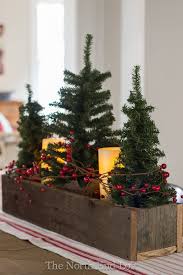Small Faux Christmas Trees And Pillar Battery Candles Wrapped With Red Grapevine Berries In A Rusti Christmas Decorations Christmas Centerpieces Christmas Deco
