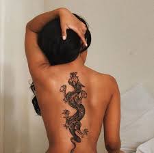 Amazing black ink dragon tattoo on women back. The Meaing Of Dragon Tattoos On Women Men The Skull And Sword