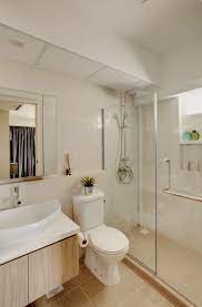 The brass mirror really stands out against the gray wallpaper while the two brown nickel and glass wall sconces tie it all together. Nice Balance Of Brown And White And There Is Ample Amount Of Natural Light Brown Bathroom Brown Bathroom Decor Beige Bathroom