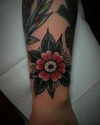 Traditional Simple Flower Tattoo Consisting Of Red And Black Colors Inked On The Left Traditional Tattoo Flowers Traditional Tattoo Wrist Black Flowers Tattoo