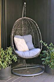lantis patio wicker hanging chair with stand and beige cushion via today s creative life chair hanging chair with stand hanging chair outdoor hanging chair