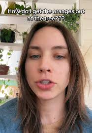 Lady Takes An Orange Off Her Tree California