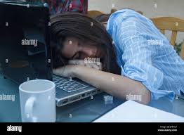 Young Entrepreneurial Chica Cansado De Trabajar Mucho Se Queda Dormida En La Parte Superior Del Ordenador Portatil Sobre La Mesa Ella Es Una Mujer De Negocios Con Demasiado Trabajo Fotografia De Stock