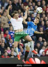 Rangers' Andy Murdoch (right) and Hibernian's Scott Allan (left) battle for  the ball in the air during the Play Off Semi Final First Leg match at the  Ibrox Stadium, Glasgow Stock Photo -