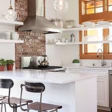 white kitchen with brick accent wall
