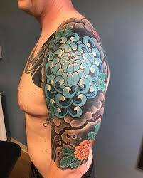 Cross tattoo with skull design in it and looking very beautiful on thigh of a women. The Bell Rose Tattoo Piercing Massive Tribal Cover Up With A Chrysanthemum Made