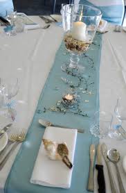 A bamboo runner, seashells and pebbles, starfish plus turquoise candles in candle holders. 52 Romantic Beach Wedding Table Settings Weddingomania