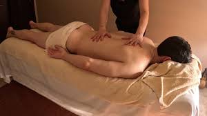 Masaje suave y relajante con aceite caliente sobre camilla.