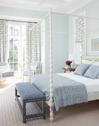 Lovely White And Blue Bedroom Features A Blue Bench Placed On A Cream Rug In Front Of White Spi Blue Master Bedroom Interior Design Bedroom Beach Style Bedroom