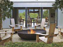 A Collection Of Graphic Updated Adirondack Chairs Surround An Indian Cooking Pot Turned Firepit In Fire Pit Seating Rustic Fire Pits Outdoor Fire Pit Seating