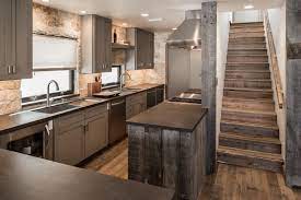 This casts a warm yellow light on the wooden table in the middle of the hardwood flooring that serves as a kitchen island. Modern Contemporary Design Kitchen Decor Modern Small Rustic Kitchens Rustic Kitchen Design