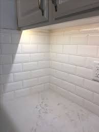 After we got all the tiles set up and all those gaps filled in, it was time to grout. The Beveled White Subway Tile Enlarges The Space To Make The Gall White Subway Tile Kitchen White Tile Kitchen Backsplash White Subway Tiles Kitchen Backsplash