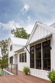 Black And White Awnings For Windows White Vertical Exterior Siding Black Trim Windows Window Awnings Dark Wood Decking Metal House Exterior White Exterior Houses Vertical Siding Exterior