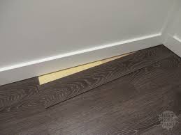 Latex caulk will seal off that gap and will expand and contract with the movement of the materials. How To Install Click Laminate Flooring Without Removing Baseboards Just Needs Paint