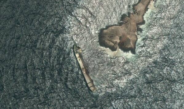 Aerial view of a grounded oil tanker leaking dark crude into the pristine waters off the coast of Oman.