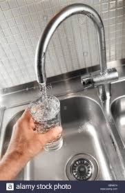 Das elegante design und die hochwertigen materialien des einhebelmischers. Eine Hand Halt Ein Glas Unter Wasserhahn In Nahaufnahme Stockfotografie Alamy