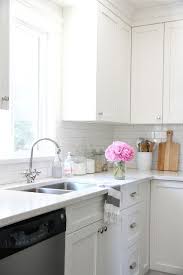 Well appointed black and white kitchen boasts a black and gold hood mounted to linear white marble backsplash tiles above a stainless steel stove fixed between white shaker cabinets painted in benjamin moore cloud white and adorned with oil rubbed bronze hardware. Our House Kitchen Renovation Outdoor Kitchen Countertops Kitchen Design