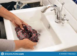 wash laundry by hand in a sink stock