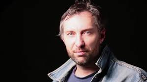 Portrait rapproché d'un motard barbu aux yeux bleus d'âge moyen prenant un  casque.