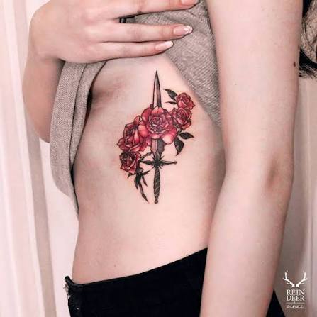 Dagger and five red roses on the left side ribcage.