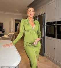 Pregnant Olivia Bowen looks stunning as she cradles her growing baby bump  in a green midi dress