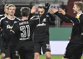 De sfeer in de duitse bundesliga is uniek om mee te maken. Kan Holstein Kiel Tegen Dortmund Nog Eens Stunten In De Duitse Beker