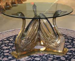 Gun metal grey with gold accents, smoky glass round tip with three folded swan motif legs measures approx 25.5 h x 24 diameter. Sold Price Hollywood Regency Style Brass Swan Glass Top Table January 5 0119 1 00 Pm Est