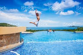 A Photograph Of A Boy Jumping Into A Swimming Pool Overlooking The Cool Swimming Pools Pool Swimming Pools