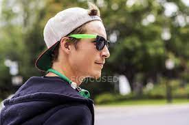 Yellow glasses guy refers to a blurred photograph of a smiling man wearing yellow sunglasses. Caucasian Man Wearing Sunglasses And Headphones In Park Street Sunlight Stock Photo 263251914