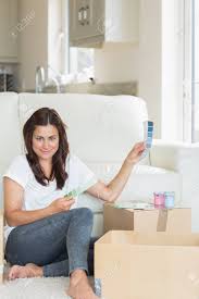 Woman Deciding Colour For Room From Charts In Living Room