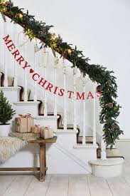 This entryway and staircase are layered with various metallics and greenery to create a festive and inviting space. 33 Ideas Decorating Christmas Stairs