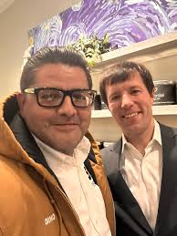 Paul Bragg, nutrition and wellness proponent, poses with a large group who  took part in a hike in the Hollywood Hills in Los Angeles. The hikers are  spread out along a trail,