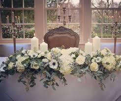 A Winter Wedding Top Table Arrangement Of Winter White Anemones Ranunculus Roses And Silver Wedding Top Table Wedding Table Flowers Wedding Top Table Flowers