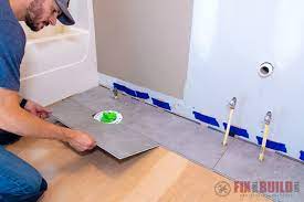 Preparing to install floor tile. How To Install Vinyl Plank Flooring In A Bathroom Fixthisbuildthat