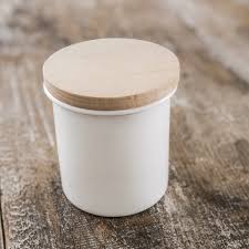 The stark white finish and decorative embossed design is enhanced by the contrasting wooden lid. Enamel Kitchen Canister In White With Wooden Lid Garden Trading