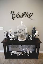 A Vintage Console Table With Black And White Skeletons Of Various Animals A Cage With Bats An Halloween Mantel Elegant Halloween Vintage Halloween Decorations