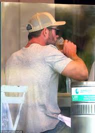 Chris Hemsworth enjoys a beer during a leisurely lunch with friends in  Sydney's Bondi