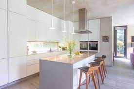 A perfect row of these stools tucked neatly under a kitchen island or breakfast bar in either natural rattan or charcoal add that inspired jungle element to your living space. Modern White Kitchen With Island And Barstools Stockphoto